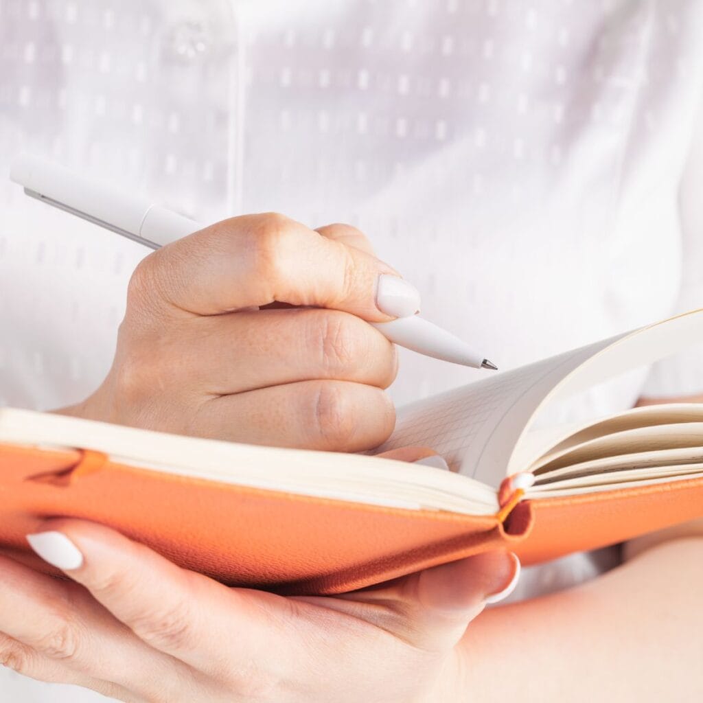 Une personne surligne les mots d'un carnet avec un stylo comme pour l'aider à choisir